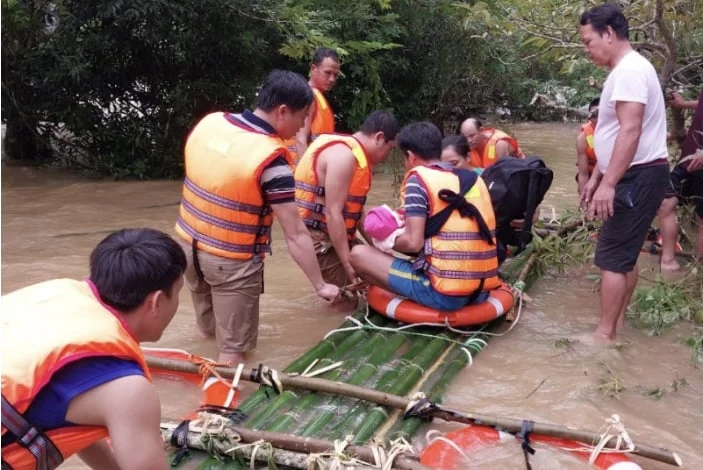 Công an xã, quân sự xã và nhân dân bản Xốp Cốp, xã Yên Thắng (nay là xã Yên Hòa, Nghệ An) chặt tre kết bè đưa cháu bé 8 tháng tuổi vượt lũ sang sông, cấp cứu kịp thời. Ảnh: Thùy Anh.